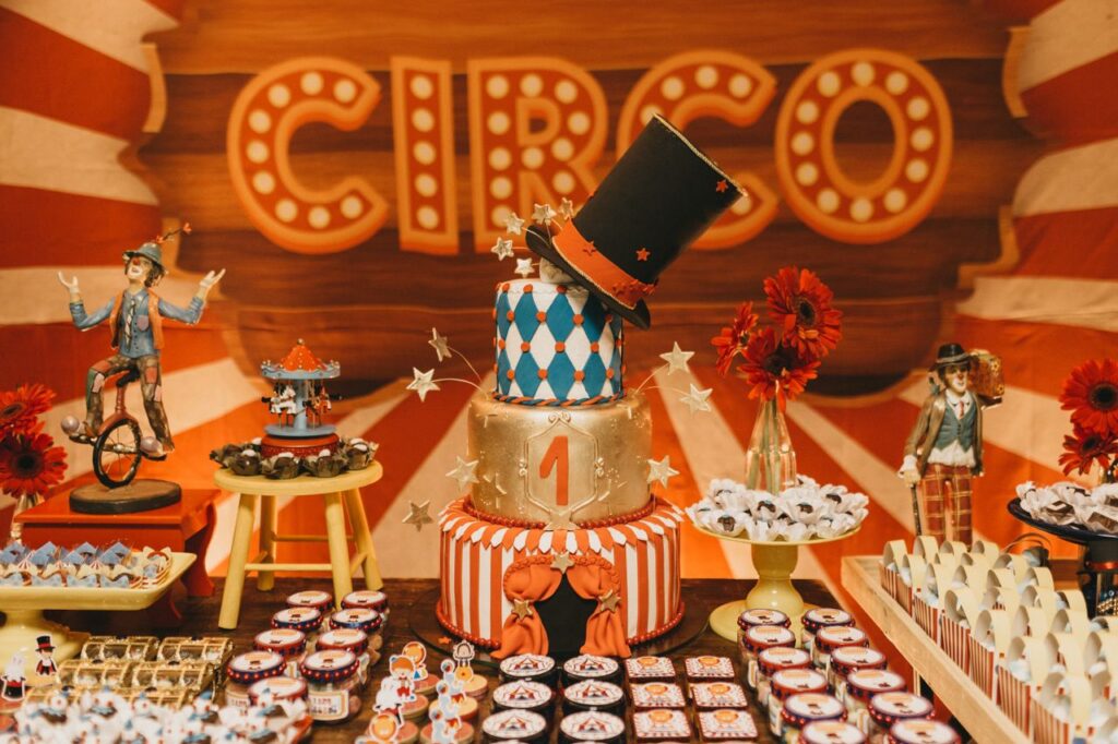 Decorated tiered cake with sweet desserts served on table with colorful decorations in theme of circus